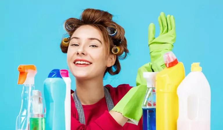 young woman with some cleaning chemicals and wearing the gloves