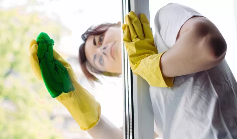 young woman cleaning window glass with a mop