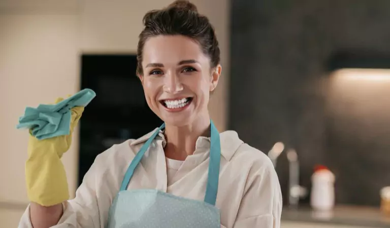 woman with a cleaning sponge ready to clean her house