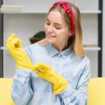 woman wearing cleaning gloves getting ready to clean
