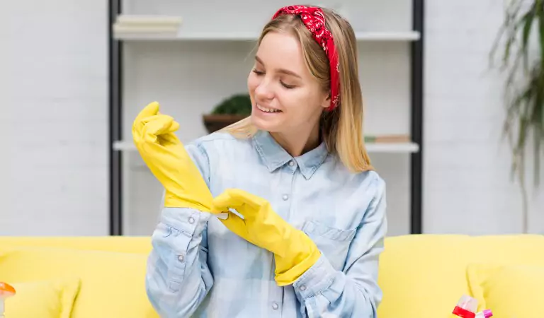 woman wearing cleaning gloves getting ready to clean