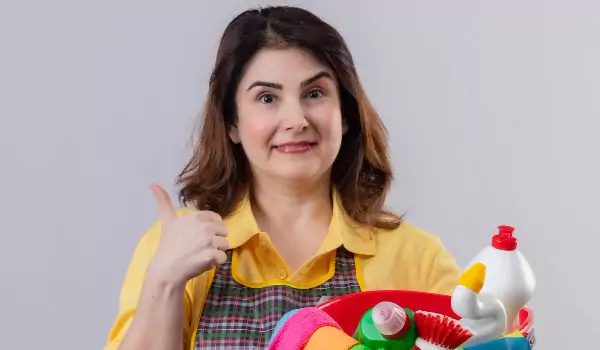 woman with some cleaning supplies ready to clean a house