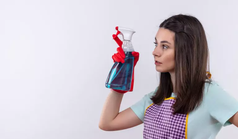 woman with a cleaning spray looking ready to clean her house