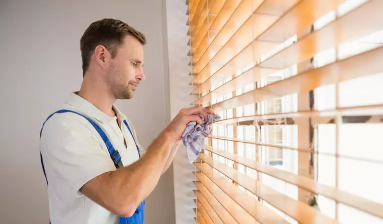 young man cleaning window blinds