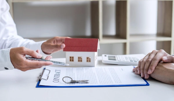 Midsection of realtor explaining contract to man sitting at desk in office