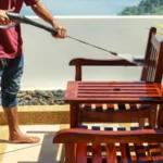 Thai man do a pressure washing on timber