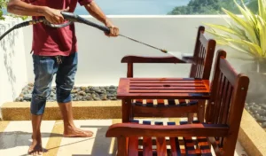Thai man do a pressure washing on timber