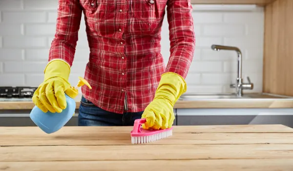 Woman with rubber gloves cleaning in the kitchen